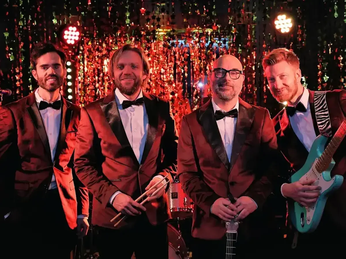De vier Notenkrakers – alle vier poserend in rode tuxedo's